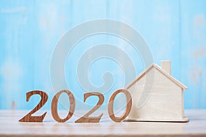 2020 number with house model on wooden background. Banking, real estate, investment, financial, savings and New Year Resolution