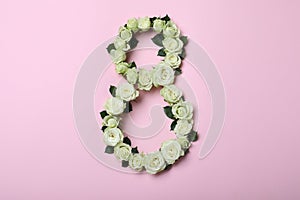 Number 8 made with white roses on pink background, flat lay. International Women`s day