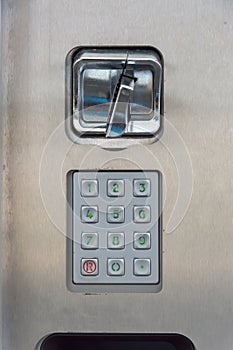A number pad with a coin slot in a stainless steel plate