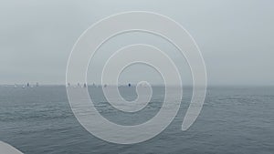 number of sailing boat in the water during a fogy day at the cost of ireland