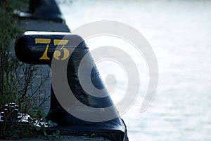 Number seventy three 73 in yellow colour on black iron noray photo