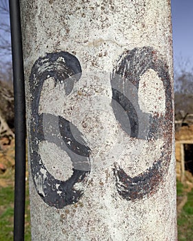 Number sixty-nine in black on a concrete utility pole