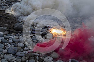 A number of smoke bombs laying on the rocky ground