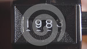 The number on a tally counter turning from 1979 to 1984