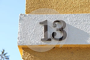 Number thirteen written on yellow and white wall