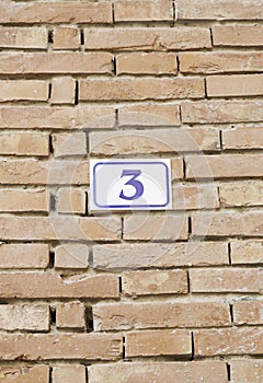 Number three on a brick wall photo