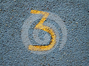 Number three painted on asphalt