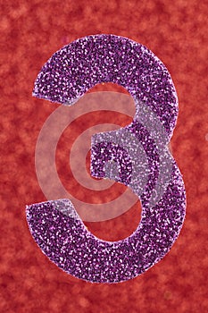 Number three purple color over a red background. Anniversary.