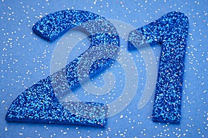 Number twentyone blue color over a blue background. Anniversary.