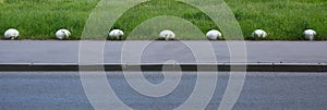 Number of white concrete hemispheres blocking the entrance of transport on the lawn