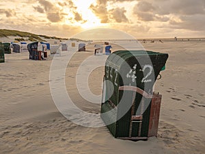 Numbered booths on the sand of the Juist island beach, Germany during sunset