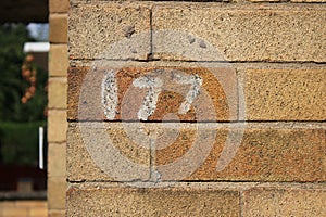 Numbers 177 painted onto a brick house