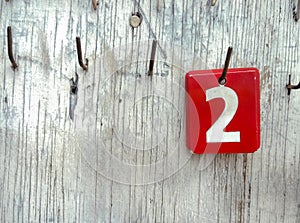 Numbers 2 on tags hanging in an old wooden