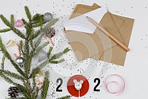 Numbers 2020 and christmas tree branches and decorations with envelopes on white background