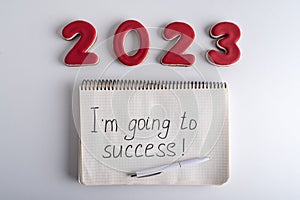 Numbers 2023 and notebook with the words I am going to success. Motivation for 2023