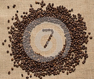 Numbers from coffee beans on burlap background