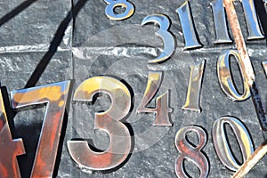 Numbers. Numbers of various sizes and types in shiny metal like aluminum for sale or exchange at street fair or open market in Bra
