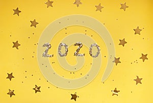 2020 numbers from small confetti with shining stars . Festive background. New Year. Top view.