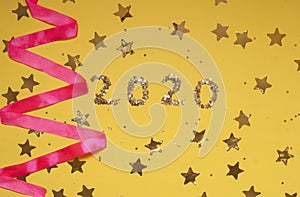2020 numbers from small confetti with shining stars . Festive background. New Year. Top view.