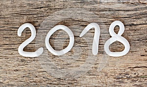 Numbers from white clay forming the number 2018, Element for a postcard new year 2018 on a rustic wooden background.