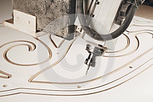 Numerically controlled woodworking machine cuts rounded complex lines on the canvas. Computer numerical control. CNC.
