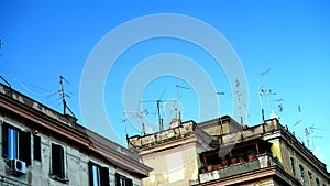 Numerous antennas and TV dishes on an ancient building, typical of many Italian cities.