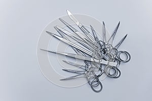Numerous surgical instruments on a blue gray background