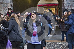 Numerous tourists are photographed in the courtyard of Juliet`s house. People make selfies