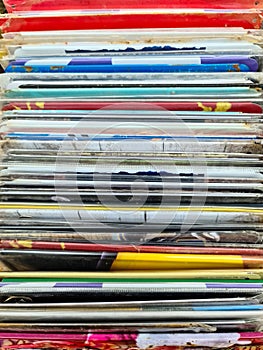 Numerous vintage signs and vinyl records in a box seen from above