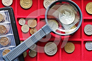 Numismatic, world coins collection on a red tray.