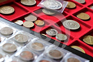 Numismatic, world coins collection on a red tray. photo