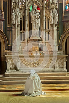 A nun in front of an altar inside Saint-Gervais Church