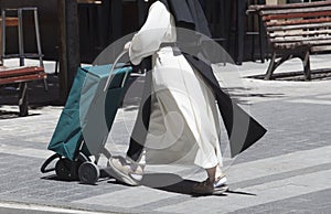 Nun in habits pushing a shopping trolley