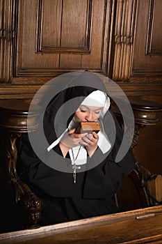 Nun kissing prayer book