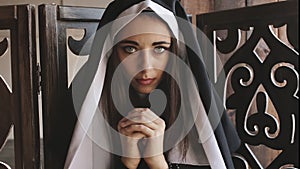 Nun pray and looks into camera