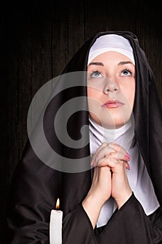 Nun praying and burning candle