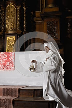 Nun ringing bells during consecration photo