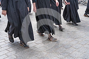 Nuns in black habits walking on a stone cobbled street