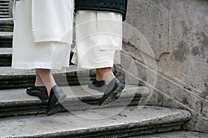 Nuns walking up steps at a convent in Europe.