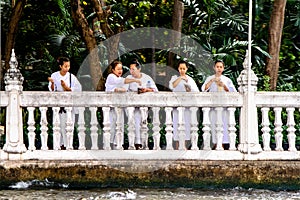 nuns in white clothes throw blossons into the river to honor the godness