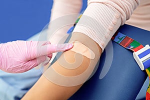 Nurce glues adhesive plaster on arm