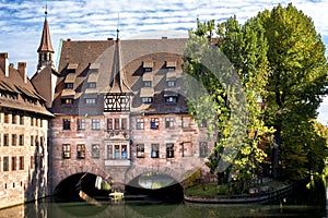 Nuremberg, Heilig-Geist-Spital which is reflected in the waters of the Pegnitz river. Franconia, Germany