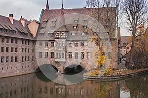 Nuremberg landmark. Medieval hospital museum house over canal. Old town of Nuremberg, Germany. Autumn landscape in old town.