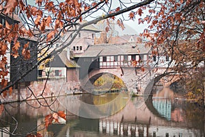 Nuremberg landmark. Medieval houses and bridge over canal with autumn trees. Old town of Nuremberg, Germany.