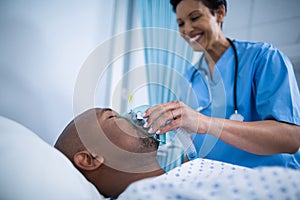 Nurse adjusting oxygen mask on patient mouth