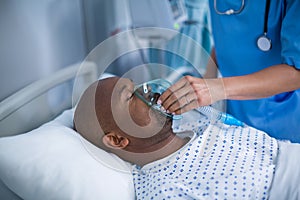 Nurse adjusting oxygen mask on patient mouth