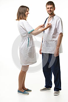 The nurse adjusts the phonendoscope on the neck of the doctor