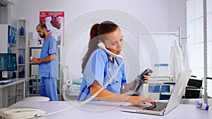 Nurse answering at hospital call checking the result of patient x-ray