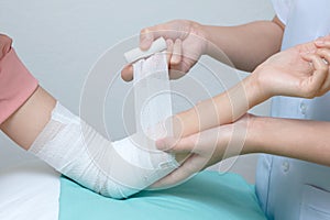 Nurse applying bandage to patient elbow