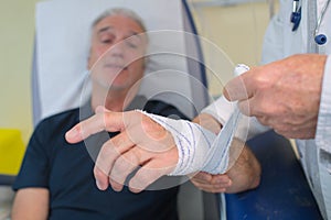 Nurse applying bandage to patient injured